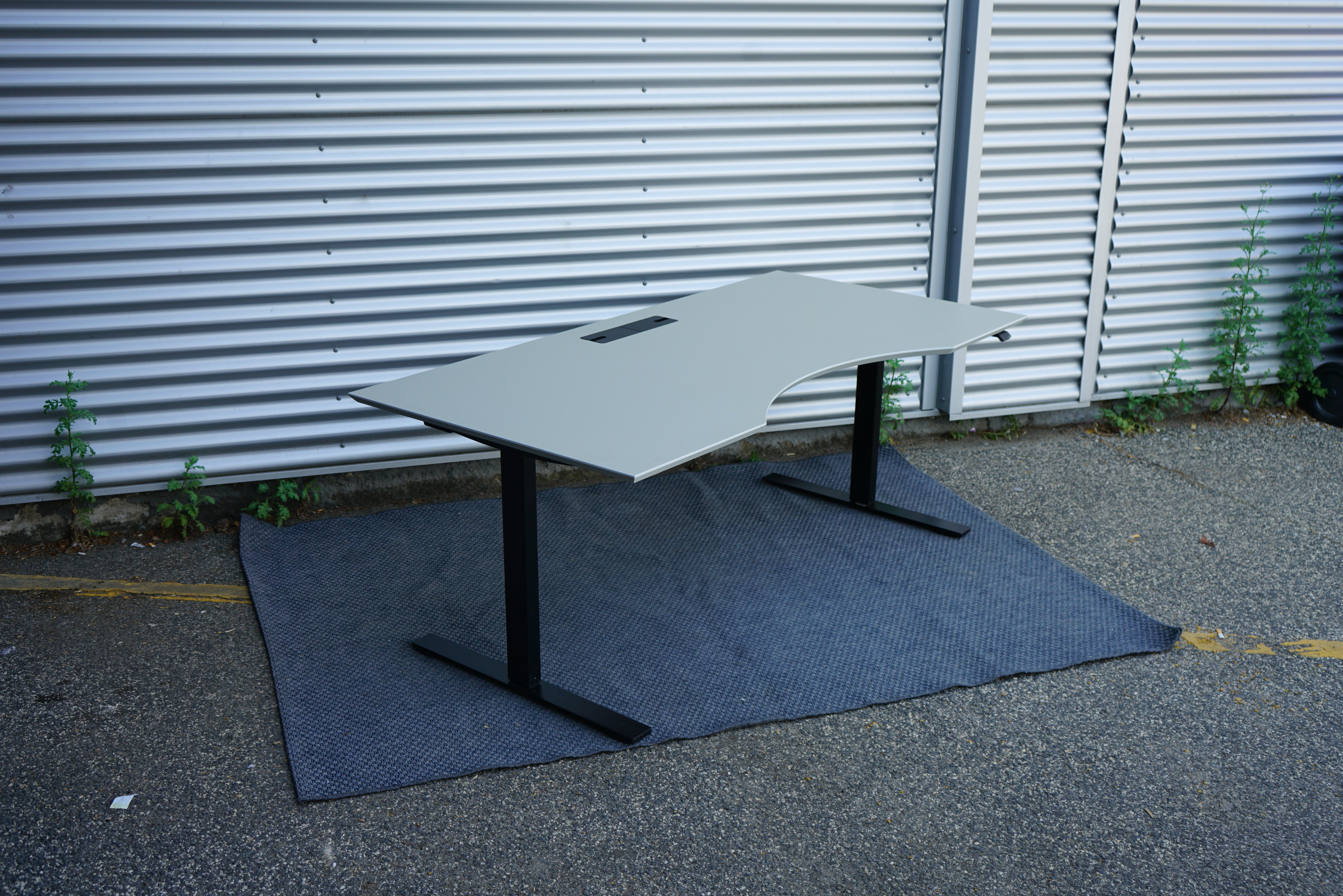 Skrå billede af Dencon Delta skrivebord 180x90 i beige med linoleum bordplade og ergonomisk kontrolpanel